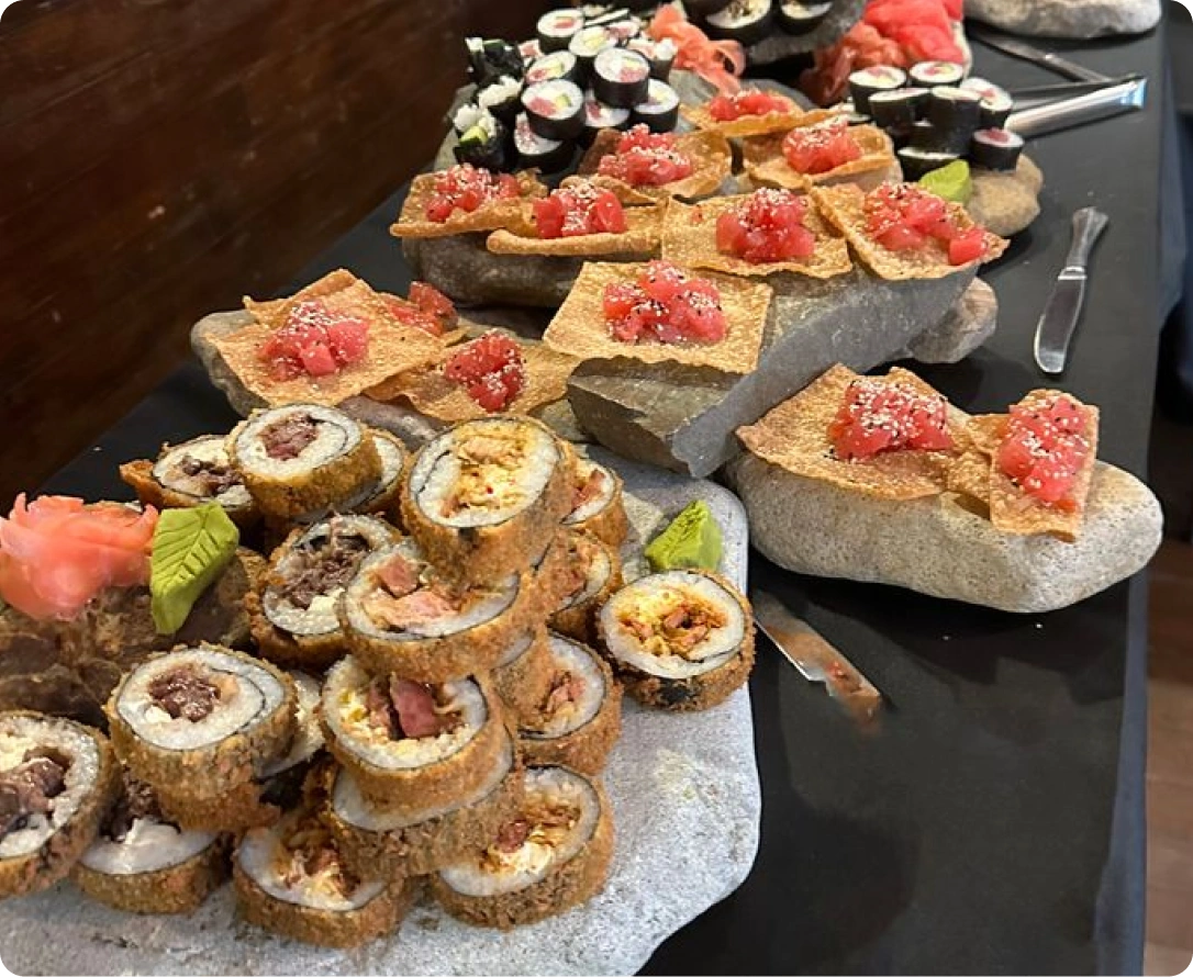 Plates of gourmet food with drizzled sauce and sesame seeds, ready for serving