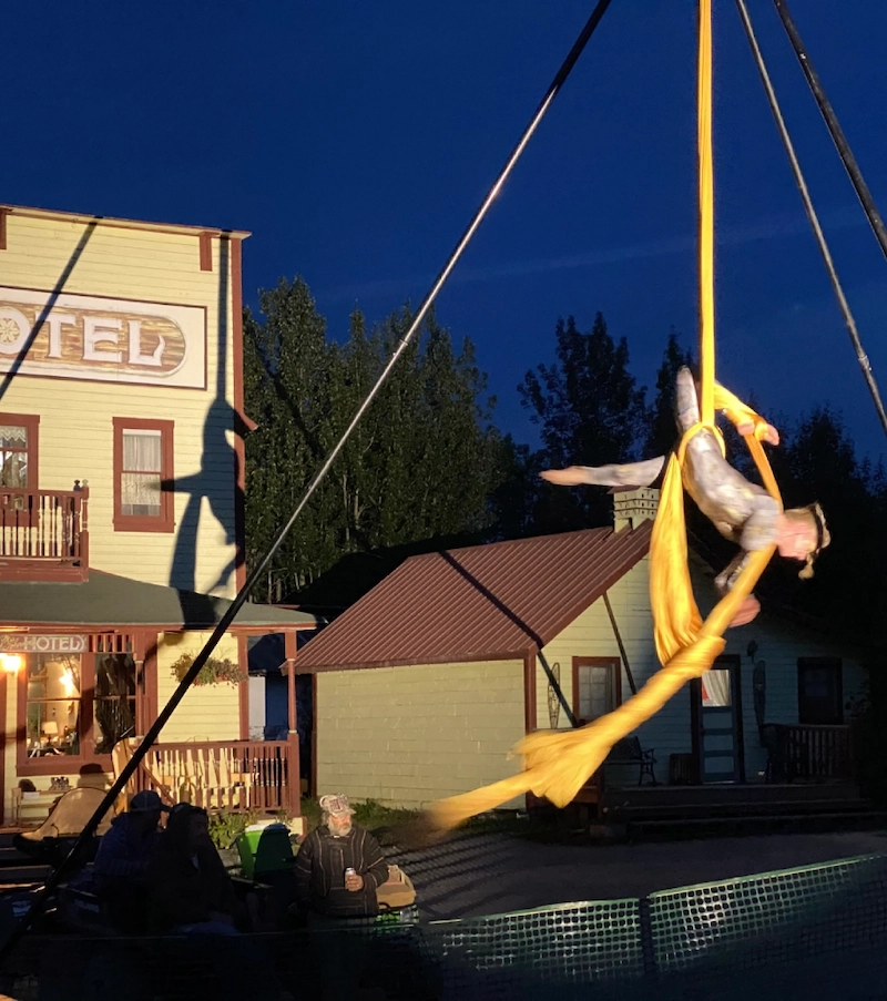 Aerial performer hanging from silk at night