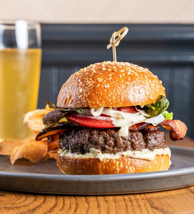 burger on a toasted bun with a side of chips